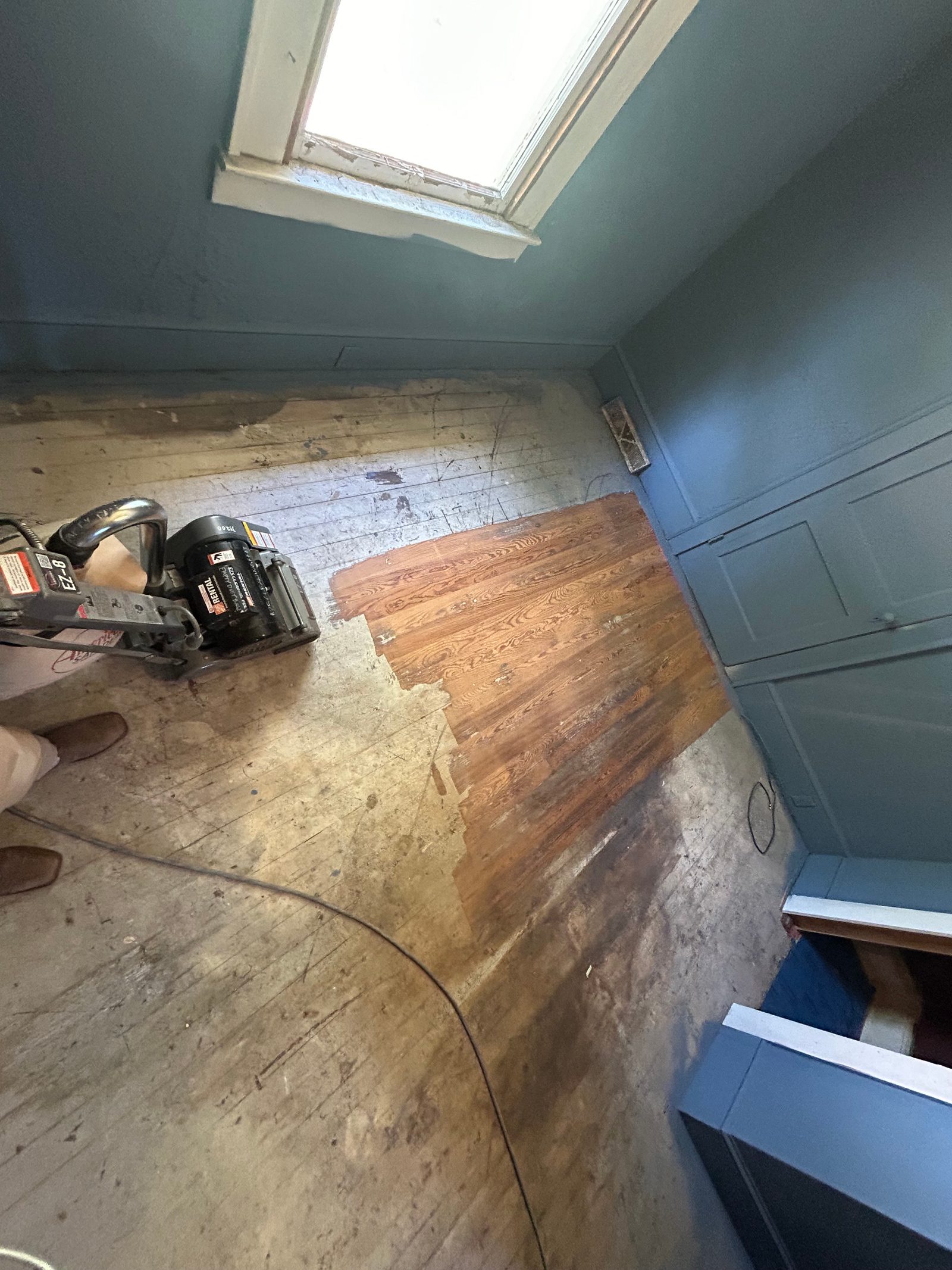 Hardwood floor sanding in progress with rental floor sander
