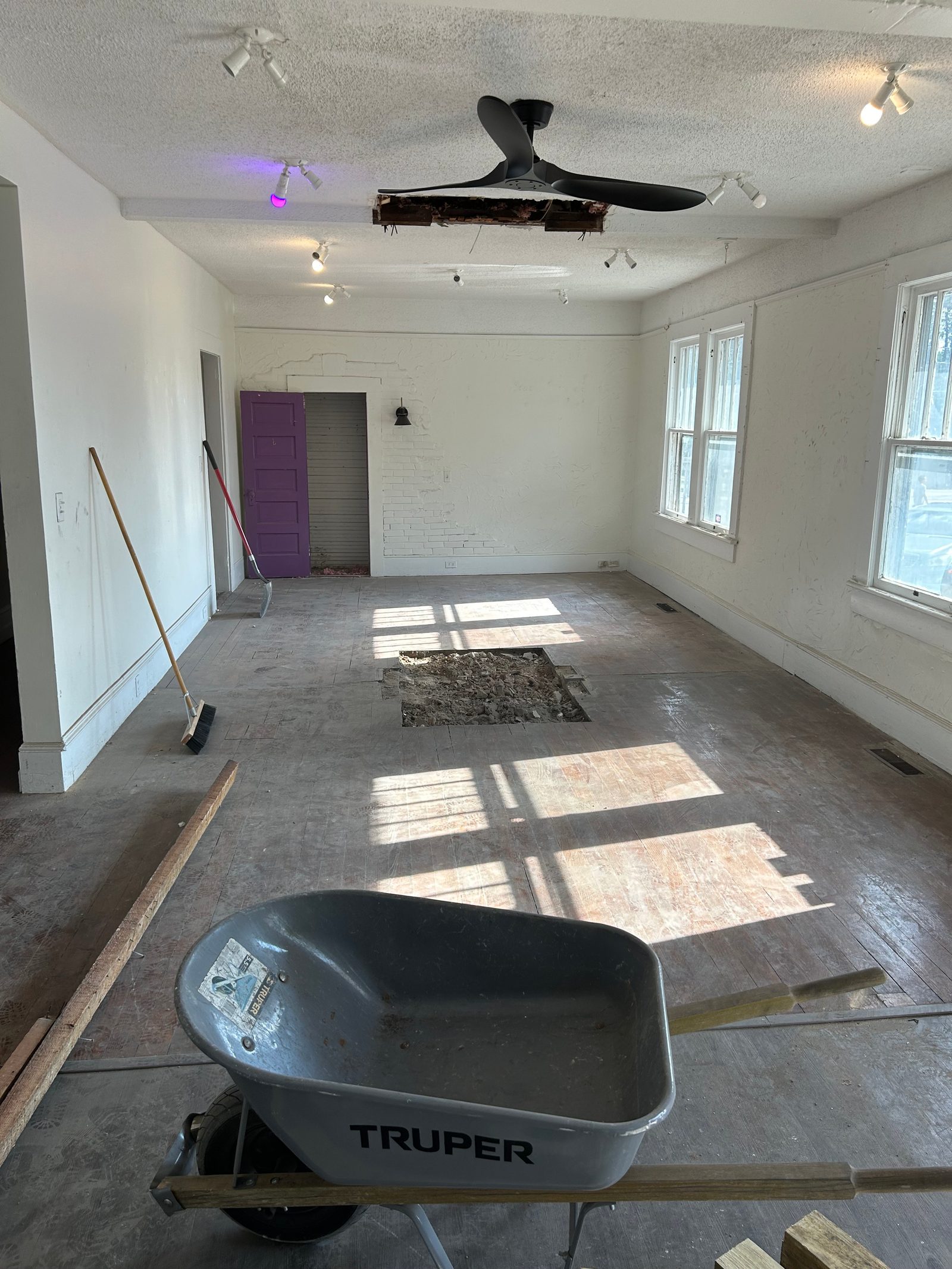 Interior room mid-renovation with exposed wall framing and skylights